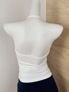 Detailed back view of a white halter neck top with open back and slim fit on a mannequin