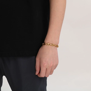 Detailed view of a gold pig nose link bracelet worn on a wrist with minimalist metal texture