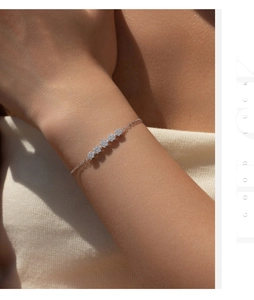 Detail of S925 sterling silver five-flower bracelet with sparkling zircon pavé on model