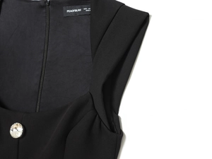 Detailed view of square neckline with large rhinestone button on black slim romper