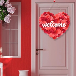 Macro detail of a heart-shaped welcome wreath with red and pink faux roses on a door