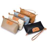 Top view of nylon clutches in five colors with brown leather trim and metal snap button