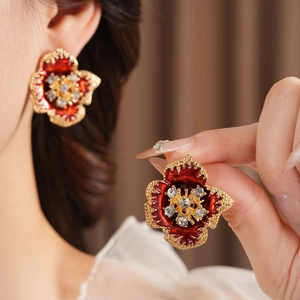 Detailed close-up of vintage enamel flower earrings with sparkling crystal accents