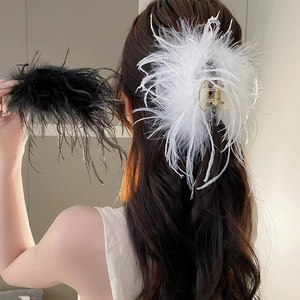 Detail of elegant ostrich feather hair claws in black and white on long wavy hair