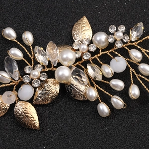 Macro detail of bridal hair vine with golden leaves, white pearls and sparkling crystals