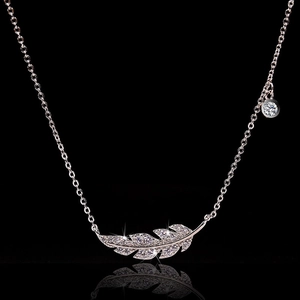 Elegante collana a piuma in oro rosa con zirconi scintillanti su uno sfondo nero