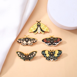 Set of 5 vintage enamel butterfly and moth pins with floral and celestial gold patterns