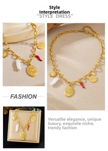 Dettaglio collana dorata con ciondolo a sole, perla barocca e charm a peperoncino