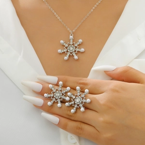 Detail shot of silver snowflake necklace and earrings set with crystal stones and pearls