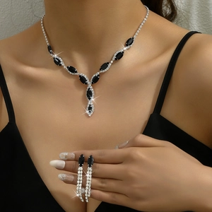 Detailed view of silver necklace and drop earrings with black marquise gems on model
