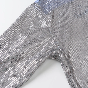 Gros plan de paillettes argentées scintillantes sur le tissu d'une chemise décontractée