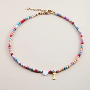 Detail of colorful beaded necklace with white heart and gold letter I pendant