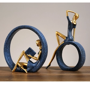 Artistic resin sculpture of a woman reading inside a blue circle with golden accents