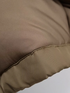 Vista macro del tessuto del parka kaki che mostra cuciture fini e materiale trapuntato