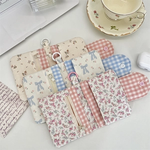 Close-up of three floral canvas coin purses with zippers and buckles in pastoral style