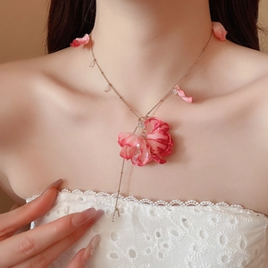 Close-up of pink silk flower petal pendant with gold beaded fringe necklace