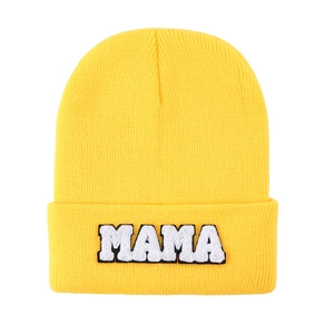 Detailed close-up of bright yellow knit beanie with white MAMA chenille embroidery patch