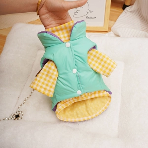 Detail of mint green padded pet vest with yellow checkered lining and windproof fabric
