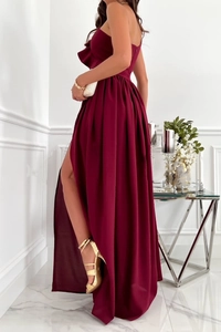Detail eines weinroten ärmellosen Satin-Kleides mit Seitenschlitz und elegantem Saum