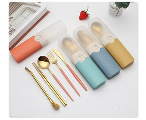 Portable golden cutlery set with colorful wheat straw cases on a clean tabletop