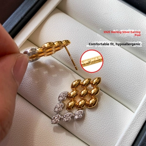 Gros plan sur les clous en argent S925 et boucles d'oreilles feuilles d'or et zircons