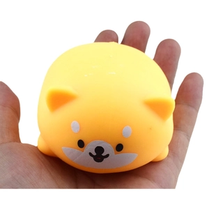 Close-up of a soft yellow shiba inu squeeze toy held in hand for size comparison
