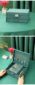 Detail view of multi-layer velvet jewelry box with necklace hooks and earring slots
