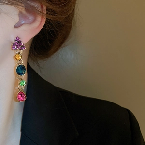 Detail view of multi-color gemstone drop earrings on model with gold finish