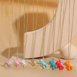 Detail showing various colors of bear pendant necklaces arranged on a stone surface