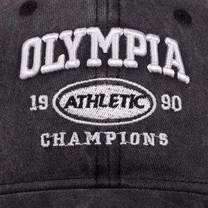 Washed dark gray baseball cap with white Olympia 1990 athletic embroidery detail