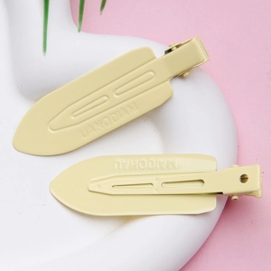 Set of two cream yellow seamless hair clips for women in a white decorative tray