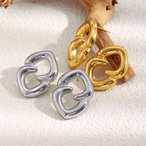 Detailed view of geometric interlocking heart stud earrings in gold and silver finish