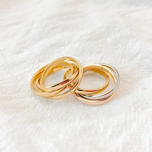 Detail of interlocking triple bands ring with polished gold and tricolor finish