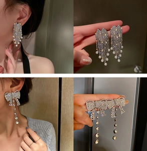 Detail of silver pin U-shaped pearl earrings with long tassels and crystal accents