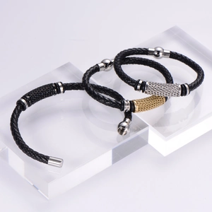 Macro shot of braided leather bracelets with silver and gold magnetic clasps on acrylic