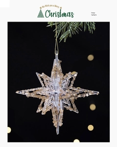 Sparkling transparent acrylic star ornament with gold sequins hanging on pine branch