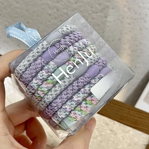 Detailed close-up of thick braided hair ties in Morandi colors and clear gift box