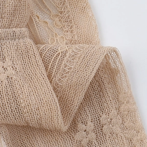 Detailed close-up of champagne lace fabric with intricate floral embroidery and mesh texture