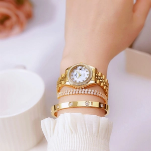 Elegant gold women's watch with diamond bezel and pearl dial on model's wrist