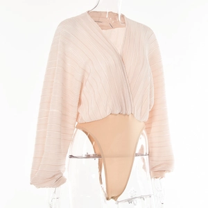 Detail view of pink pleated V-neck bodysuit with long lantern sleeves and beige bottom