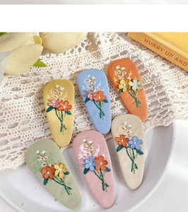 Detailed embroidery flower patterns on colorful teardrop-shaped fabric hair clips