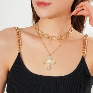 Detail of layered gold choker and cross pendant necklace with pearl on a model neck