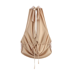 Detailed view of the champagne sequin halter top with open back and lace-up ties