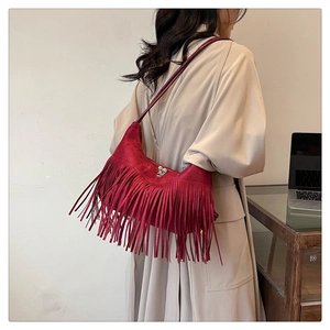 Détail du sac à bandoulière en daim rouge foncé avec de longues franges de style rétro
