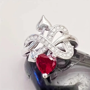 Elegant silver heart ring with red gemstone and micro-pave crystals on black stone