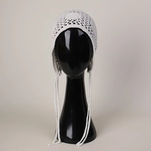Détail du motif au crochet blanc et des liens de serrage du bonnet à protège-oreilles