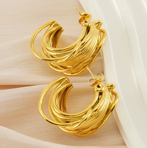 Detailed close-up of 18K gold-plated multi-layer twisted C-shape hoop earrings on silk