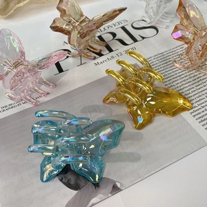 Detail of iridescent butterfly hair claws showing colorful resin texture and metal springs