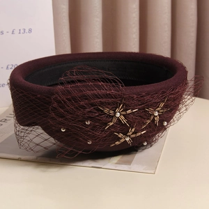 Detail of burgundy wool beret with delicate mesh veil, star beads, and white pearls