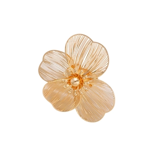 Detailed close-up of golden hollowed floral brooch with intricate wire-shaped petals